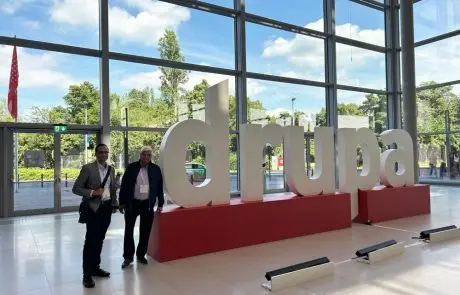Our founder and managing director next to a DRUPA 2024 sign at the event